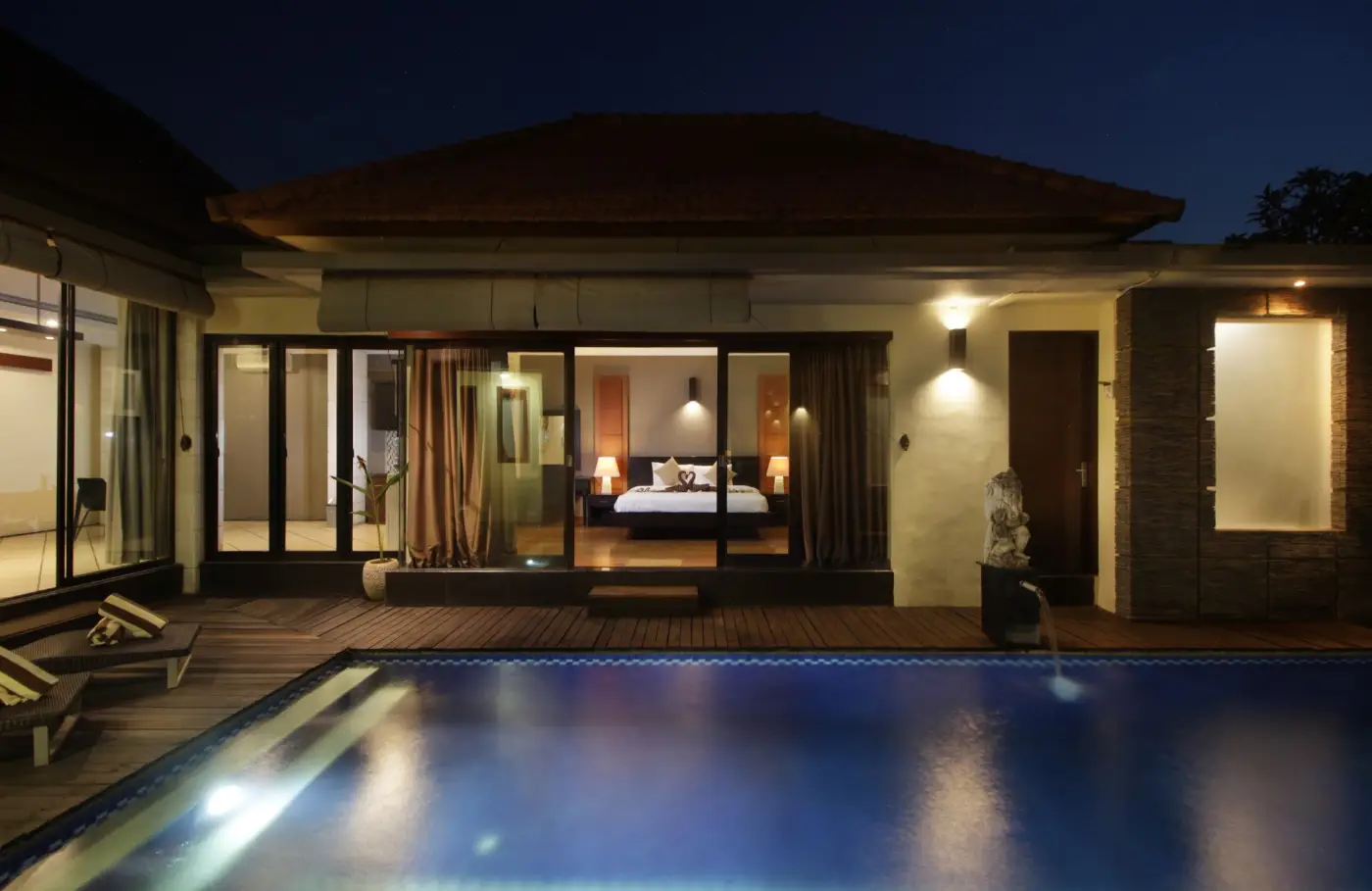 Jayani Villa: The villa lit across the pool at night